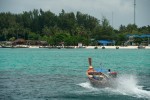 A longtail boat driver heads to shore. Longtail boats are used daily to shuttle tourists around the island and for various forms of fishing. 