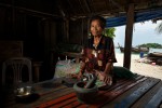 Ayun uses her mortar and pestle to mix curry paste on the porch outside her home on Sunrise beach. The Urak Lawoi' traditionally live in homes and villages on the beach and in the past would seasonally move locations on the island away from the prevailing winds.  