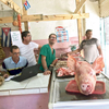 Photo of men selling fresh killed pork inside a butcher shop in Old Havana, Cuba.
