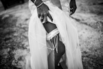 A young bride lifts her dress to show a garter on her upper leg at a beach wedding in Koh Samui, Thailand.