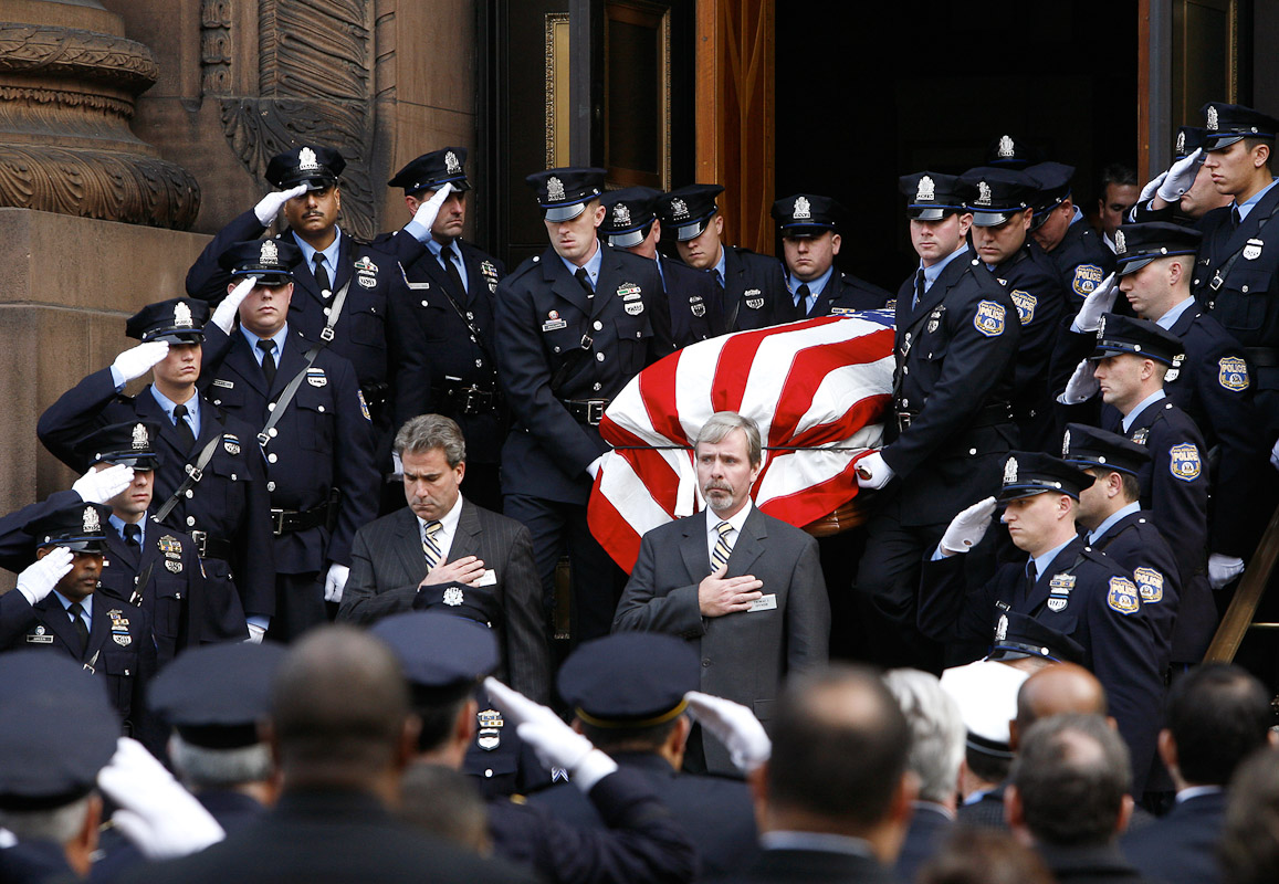 The casket of Philadelphia police sergeant Timothy Simpson, who was killed in the line of duty, is carried by officers out of the Cathedral Basilica of Saints Peter and Paul in Philadelphia following his funeral services.