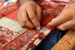A man repairs a carpet in Istanbul, Turkey.
