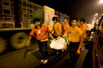 Volunteers carry a dead body to a truck bound for the morgue in Bangkok.