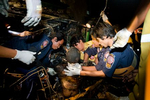 The burnt body of a man involved in a head-on collision is removed from a vehicle in Bangkok.