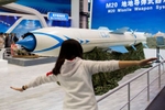 Woman poses with supersonic cruise missile system, China International Aviation & Aerospace Exhibition, Zhuhai.