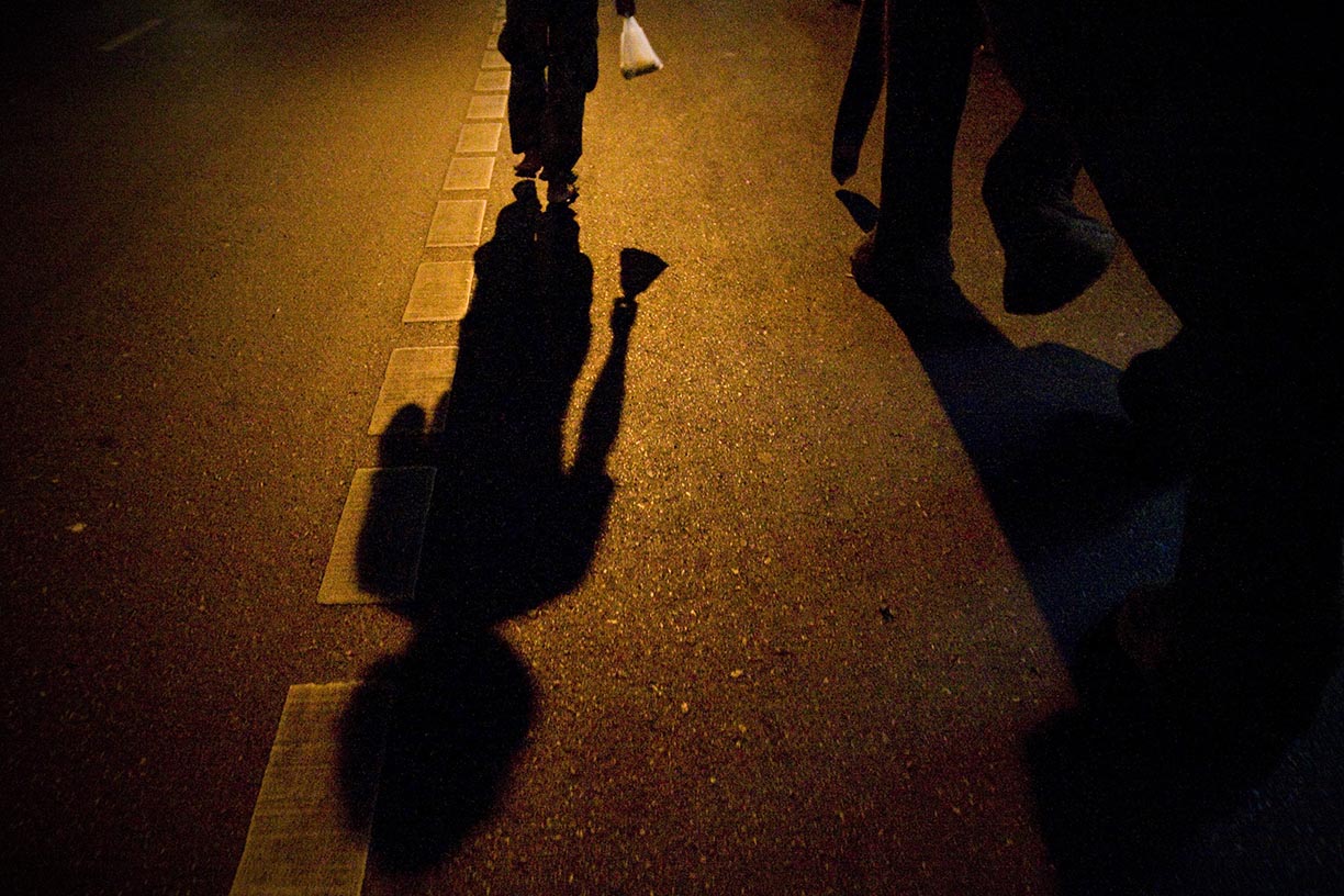 Shadows are cast from mahout, Wan, left, and his pet elephant Boopae as they walk down Sukhumvit road in Bangkok. 