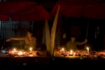 Candles provide light for vendors selling raw meat at Theingyi market.