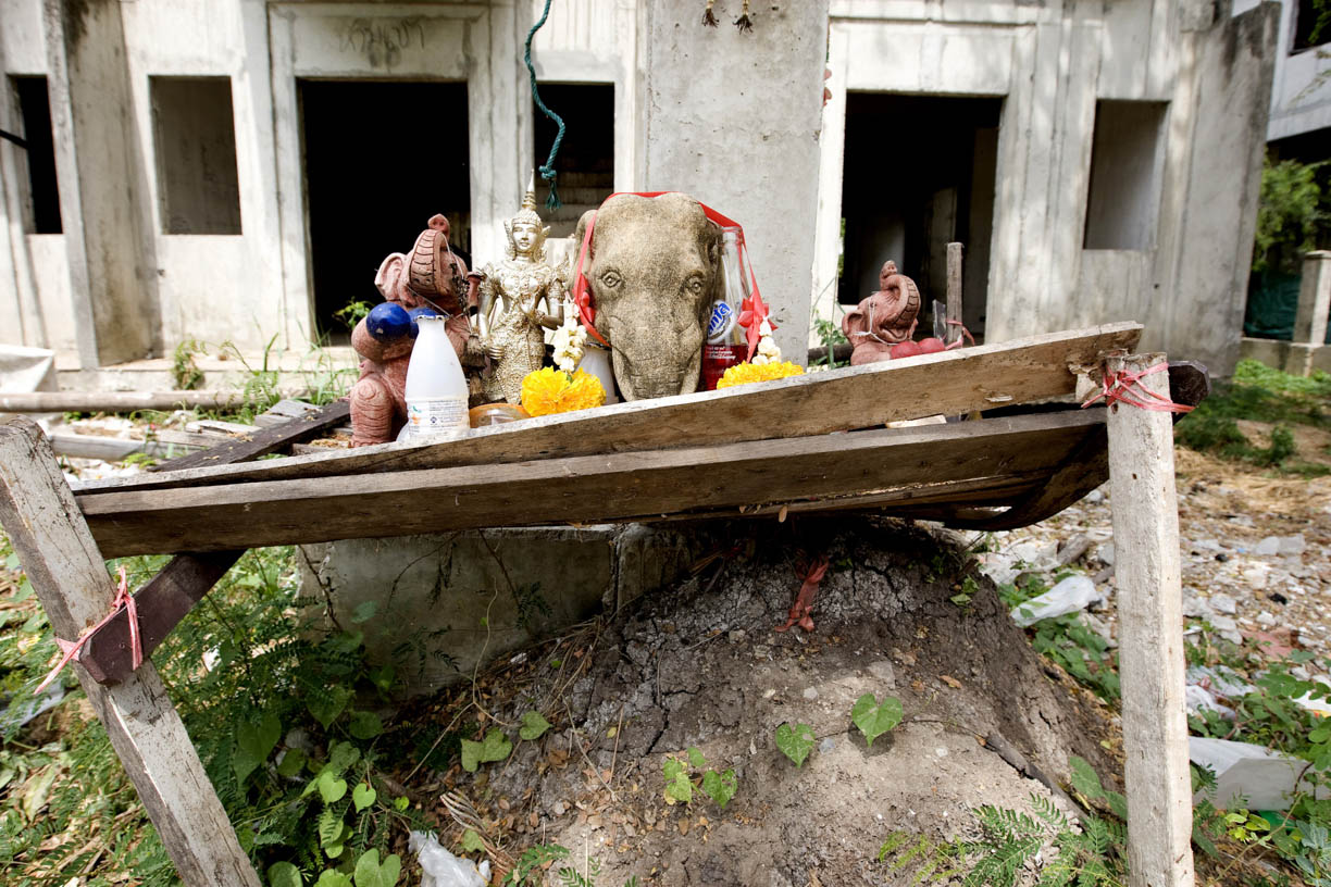 A makeshift spirit house featuring elephants sits outside the home of mahouts at an abandoned housing development in Bang Bua Thong, Thailand.