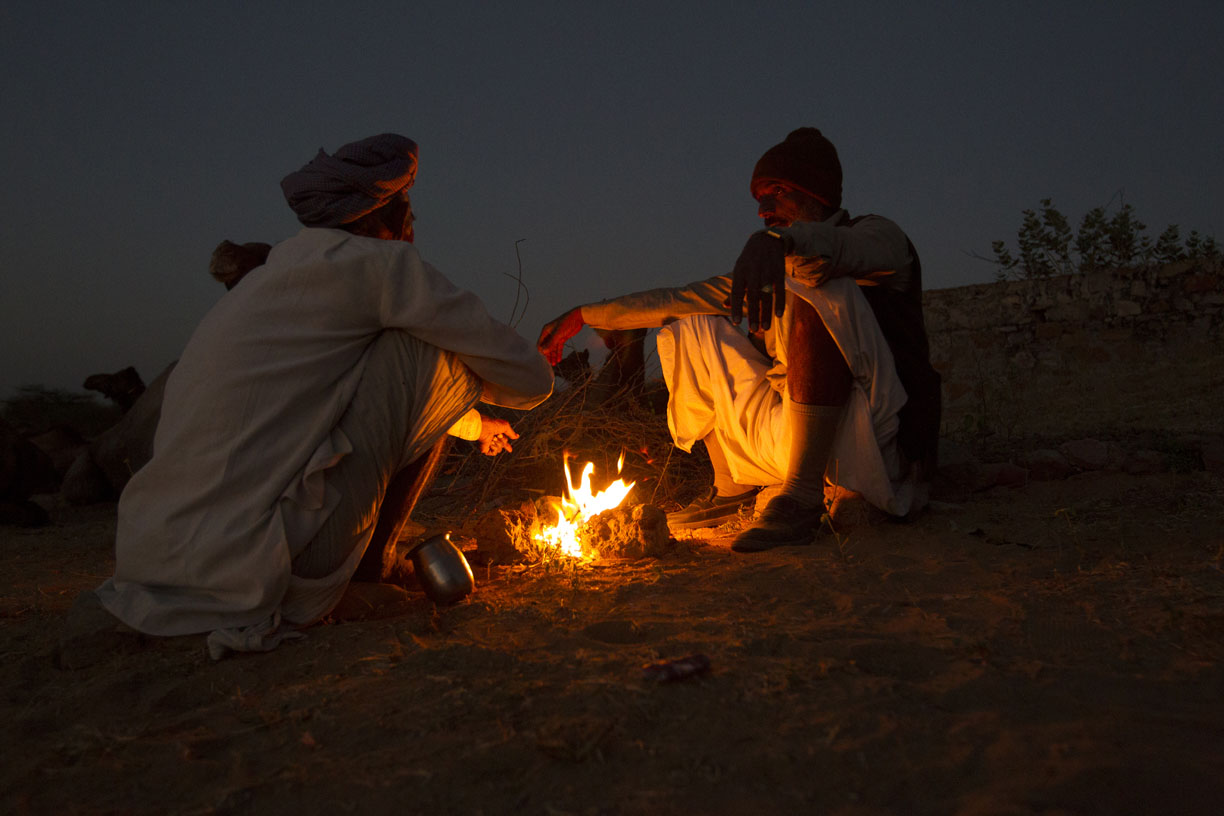 Camel traders keep warm around a fire in Pushkar. 