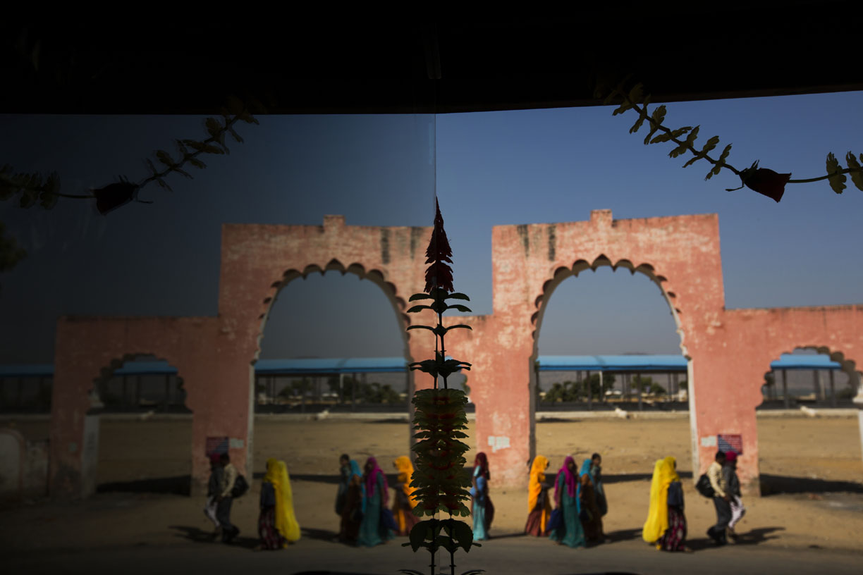 Hindu pilgrims are reflected on glass in Pushkar. 