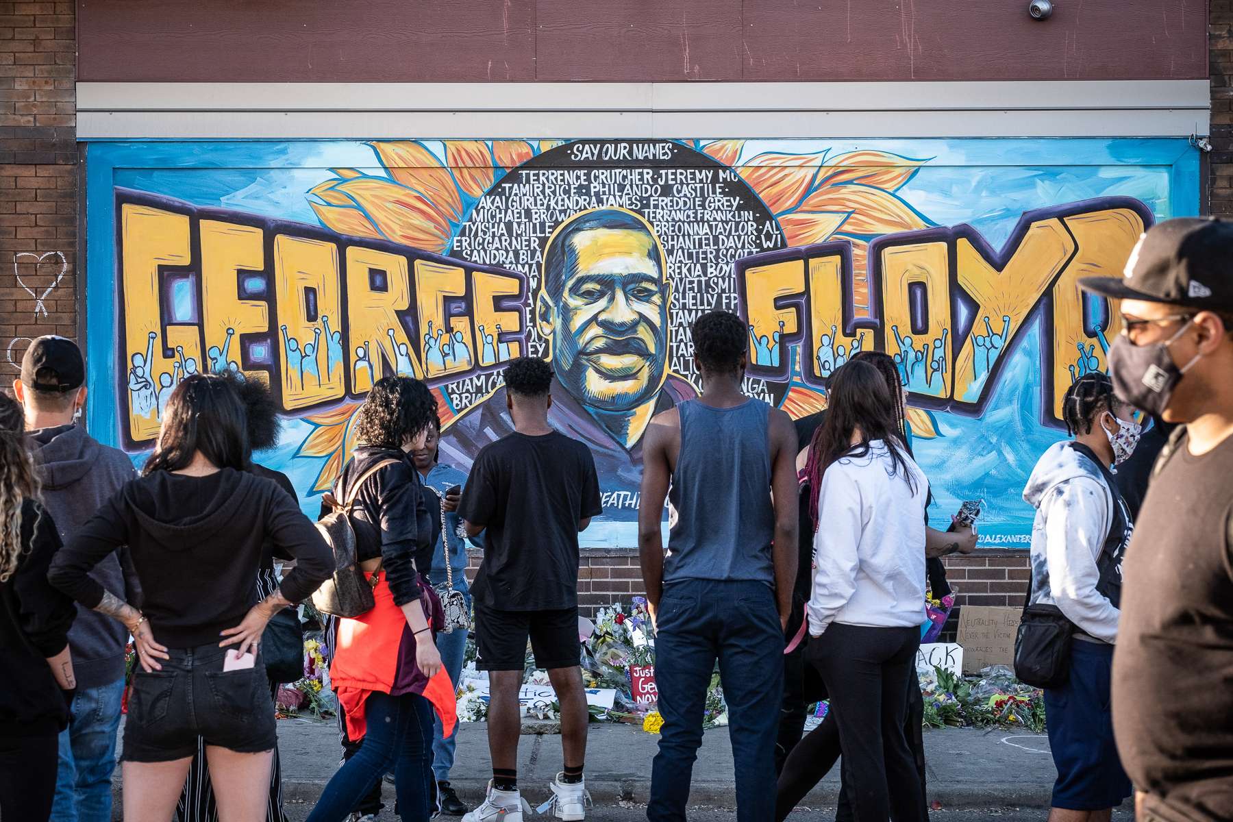 Community members gather at a mural done in tribute to George Floyd at East 38th Street and Chicago Avenue, the site where George Floyd was killed by police on Friday, May 29, 2020 in Minneapolis, MN.