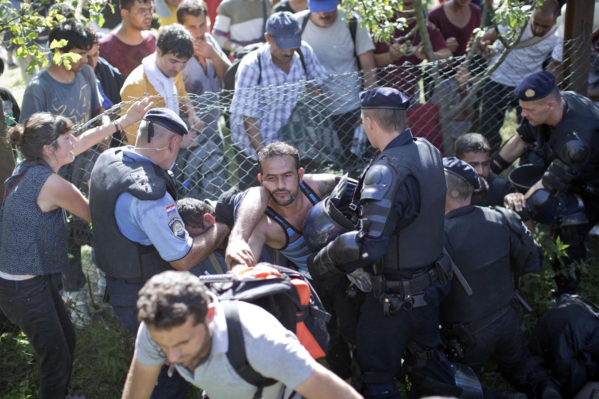 People break through a police line as a crowd of refugees converges on a train station, Tovarnik, Croatia, Sept. 17, 2015. 