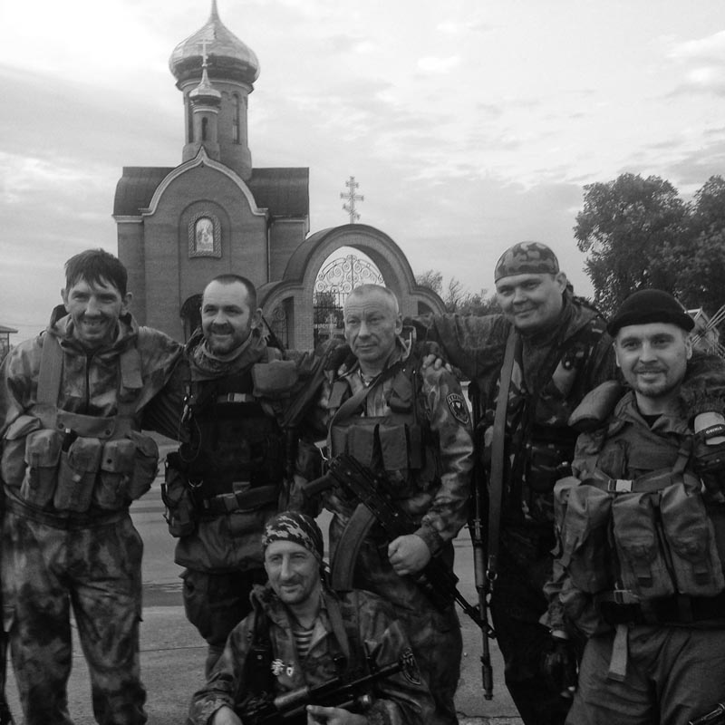 June 18, 2014. Pro-Russian militiamen, Karlovka, Ukraine. Sun sets. Two sides at war meet on a road bridge over a body of water. Ukrainians wave a white flag. Bodies are exchanged. Huge white cross at background. We finish filming. The guys ask us to take their photo after it's done. Friendly bunch. On our way back, a drunken soldier fires a warning shot in the direction of A.'s minvan. A. tells him to fuck off, then lights his pipe. 