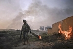 A U.S. army soldier from Fox Troop, Sabre Squadron, 3rd Armored Cavalry Regiment, sets an abandoned house on fire, Diyala province, Iraq, 2008.