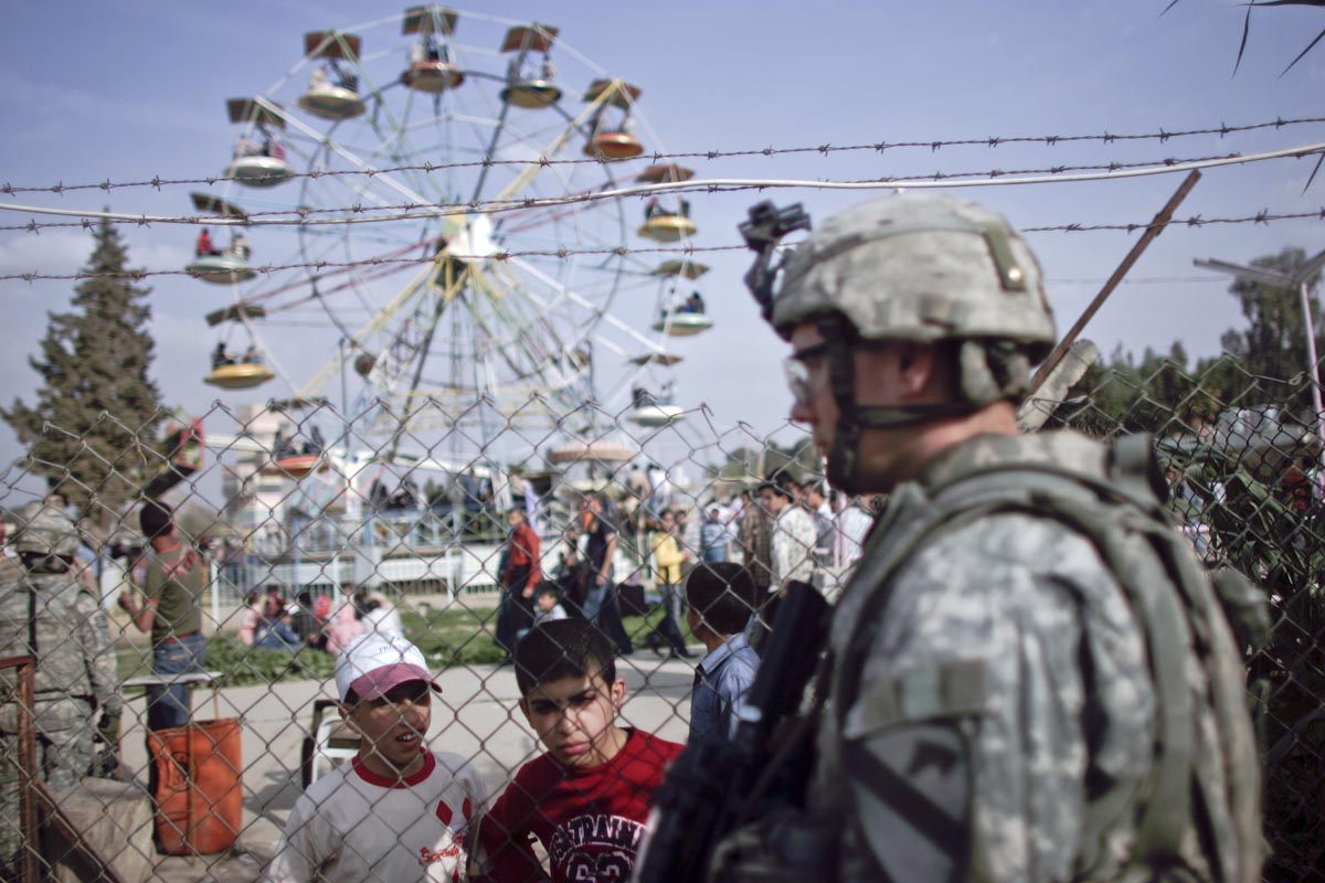 A U.S. army soldier from Warrior Battery, 2nd Battalion, 82nd Field Artillery Regiment, patrols an amusement park, Mosul, Iraq, 2009.
