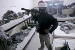 A U.S. army soldier from Blackfoot Company, 2nd Battalion, 23rd Infantry Regiment poses for a photograph while wearing a balaclava and a Santa hat and carrying a confiscated RPG launcher, Diyala province, Iraq, Christmas, 2007. 