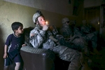 A U.S. army soldier from Blackhawk Company, 1st Battalion, 23rd Infantry Regiment, lights a cigarette during a house search, Baghdad, Iraq, 2007.