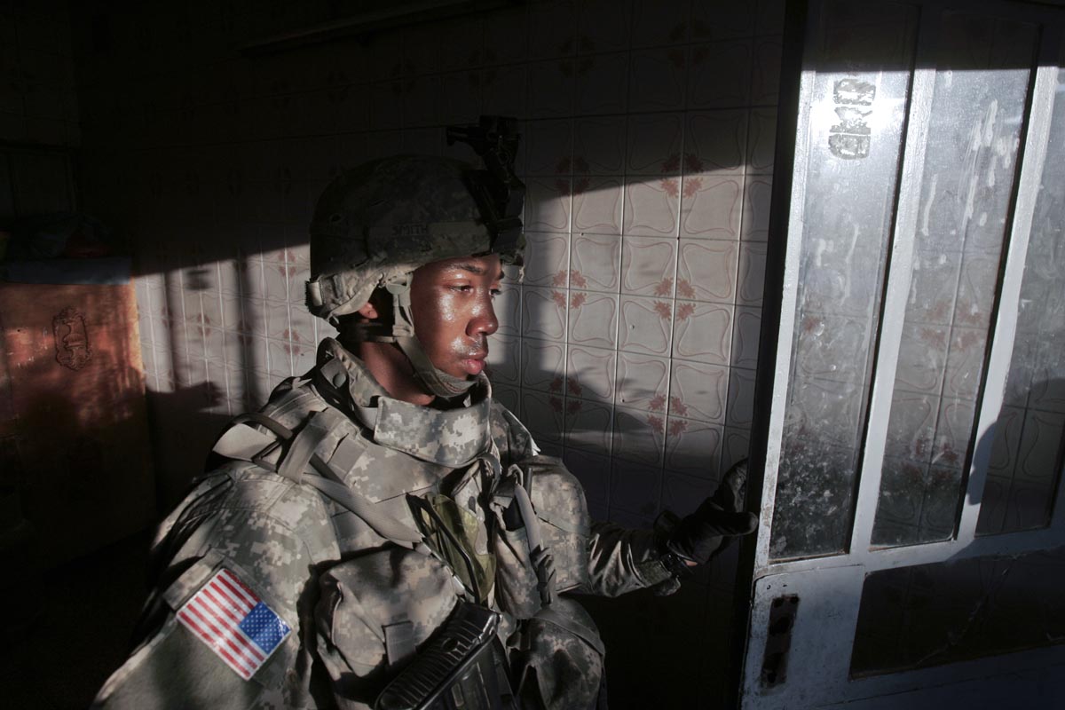 A U.S. army soldier from Blackhawk Company, 1st Battalion, 23rd Infantry Regiment, exits a house that his platoon had finished searching, Baghdad, Iraq, 2007. 