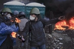 A youth gets ready to throw a petrol bomb at government positions, Kiev, Ukraine, Feb. 20, 2014. 