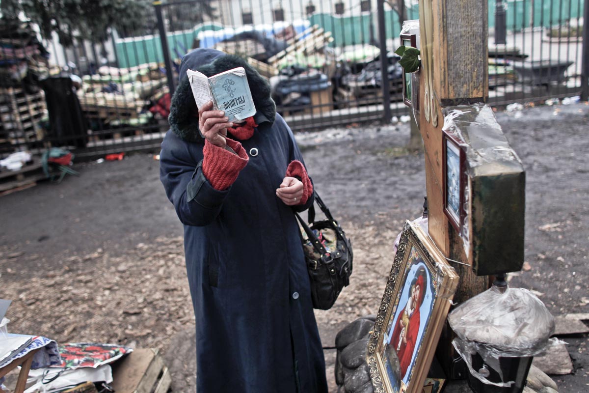 A woman prays outside the parliament biuilding, Kiev, Ukraine, Feb. 22, 2014. 