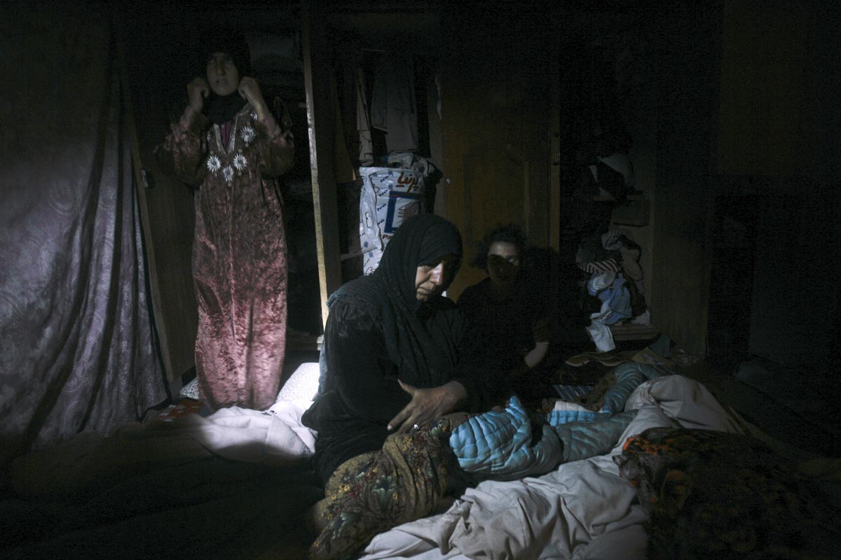 Two women and a child are awoken by U.S. army soldiers from Blackfoot Company, 2nd Battalion, 23rd Infantry Regiment, as they search their house during a night raid, Diyala province, Iraq, 2007.