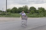 Simo Spasic, the president of the Association of families of kidnapped and murdered persons in the 1998-1999 Kosovo war, speaks through a bullhorn during a Serbian ultranationalist gathering, Jarak, Serbia, May 6, 2018. Spasic is holding a poster depicting fifteen missing members of the Kostic family, taken from their homes and presumably murdered by ethnic Albanian guerrillas in 1998. 