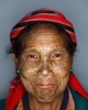 Awe Phan, age 53, poses for a photo in Myanmar's Chin State. The sparsely populated Chin State is home several subgroups all calling themselves Zo-mi meaning 'mountain people.' Separated from the rest of Myanmar (formerly Burma) by mountains and being a travel restricted State for foreigners, the Chin have little contact with the modern world. Historically the Chin were adored for their beauty and King's would come to villages to steal men's wives. As a measure against their women being stolen, village elders started tattooing teenage girls to make them 'ugly'. The tradition stuck and over generations eventually lost it's original meaning of ugliness and came to represent courage, beauty and strength. However, as these traditional groups began moving outside their villages, the struggle between tradition and modernity has placed tribal Chin culture under increasing threat of being absorbed by the dominant Burmese. Unique language, customs and dress have been abandoned. Under this pressure to assimilate, the practice of facial tattooing has also been discontinued. Currently there remain only a handful of women adorning facial tattoos.