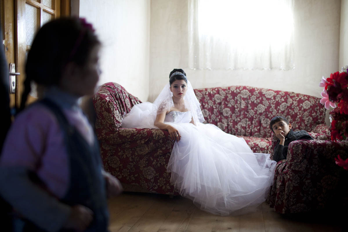 A 17-year-old Georgian-Azeri bride in the Kakheti Region waits for the groom to arrive on their wedding day. She and her 22-year-old husband-to-be met one month earlier, the day their engagement was announced.
