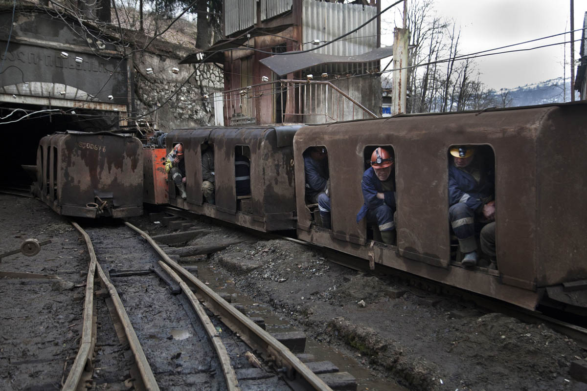 Georgia, Chiatura City. Miners sit in a mining train on their way into the tunnel.