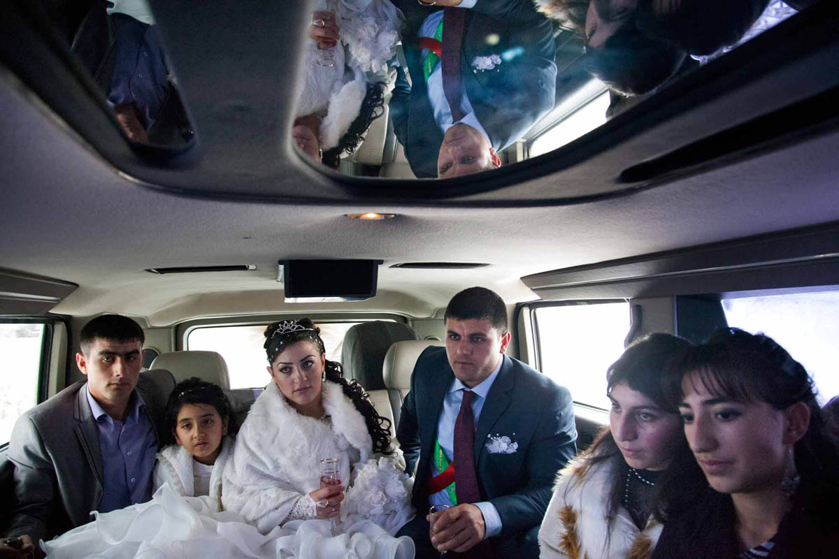 GEORGIA. Orja Village. Wedding ceremony. Inside a jeep hummer riding outside in a village of Orja as the groom and bride seat with their friends and relatives.