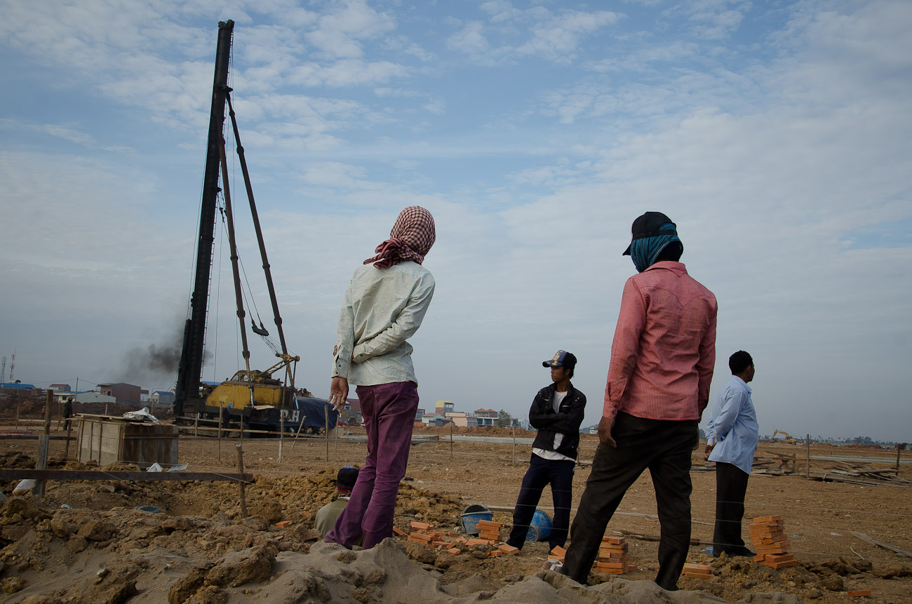 Construction workers survey the land at the New World mega housing project on the outskirts of Phnom Penh. December 2011
