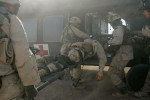 A gravely wounded U.S. soldier is loaded onto the helicopter for medical evacuation. Only one of the two reported wounded was at the landing zone as one soldier was driven to the nearby hospital. Suffering from two severed legs and an open stomach wound, medics on the ground applied two tourniquets to the wounded soldier on the scene where his vehicle was ambushed by a grenade attack. 