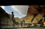 A car with a photo of the revered leader of the Panjshir resistance against the Russian invasion, Ahmed Shah Massoud, drives past horsemen after a buzkashi match in the village of Khenj, Afghanistan on October 26, 2007.