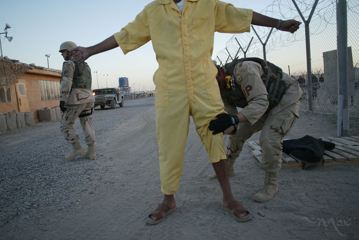 Corporal Scott Horton pats down a prisoner to take him to a family visitation session at Camp Redemption in the Abu Ghraib prison complex. Once detainees greet their visitors, the U.S. solders will take a digital photo of them together and hand them the images before they leave. 