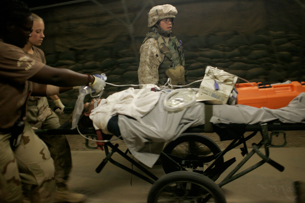 A wounded soldier and fellow Marine sent as care taker rush to the emergency room of the Air Force Theater Hospital in Balad, Iraq on August 27, 2005. 