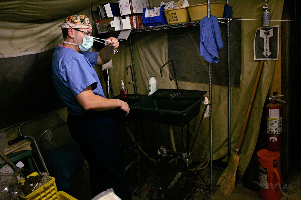 Colonel Elisha Powell the commander of the Theater Medical Hospital of the 332nd Expeditionary Medical Group, at Balad Air Base takes his mask off and cleans up in the field and tent operating room where he prepares wounded soldiers for their flight to Germany for more advanced surgery.  