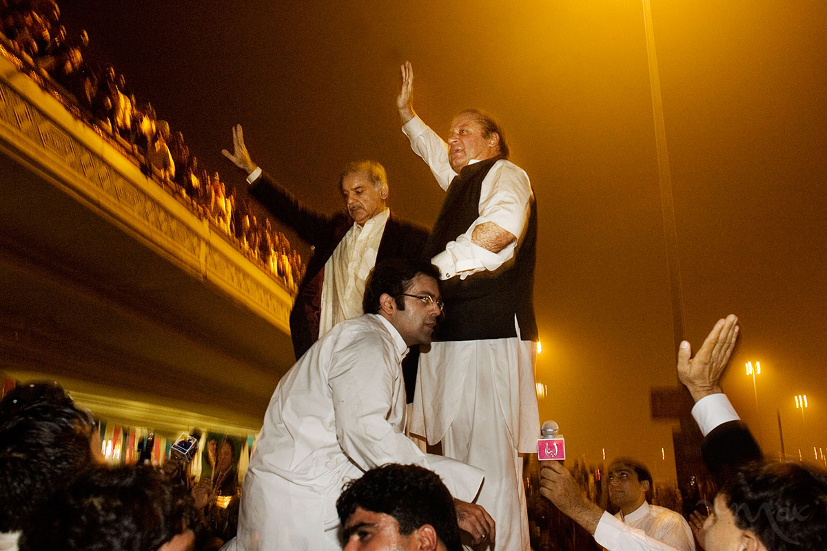 LAHORE, PAKSITAN. Former Prime Minister Nawaz Sharif, right, and his brother Shahbaz Sharif, left, stand on the top of a vehicle as they wave to hundreds of supporters after arriving at the Lahore Airport from Saudi Arabia on Sunday, November 25, 2007 in Lahore, Pakistan. President Pervez Musharrif sent Sharif and his brother into exile some eight years ago. He has arrived in Pakistan to head one of the country's leading opposition parties.
