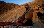 Moulana Latife, 45, prays on an outstretched jacket at the mouth of his mine in the mountains overlooking the Panjshir Valley village of Khenj, Afghanistan on Thursday October 25, 2007. Latife has been working in the mines since he was 16 and fought with Ahmed Shah Massoud against the Russians in the 1980s and the Taliban after that. Most of the men at the times are deeply independent and conservative and trying to make a living from the back breaking work. 