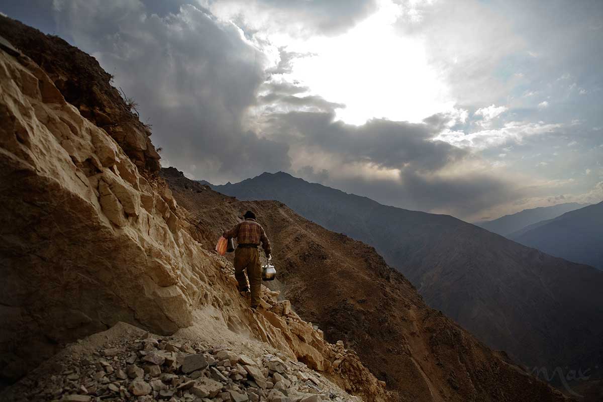 Having delivered a lunch of rice and lamb meat, Rahimullah, 27, scales the sheer rock face back to the stone cabin where he will clean up the pots and pans from the meal before returning to continue mining on mountains over the Panjshir Valley village of Khenj, Afghanistan on Wednesday, October 24, 2007. 