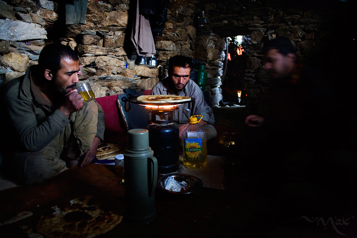 Ahmad Jawead, 22, left, Rahimullah, 27, center, and Burhan Amin, 26, right, share a breakfast of cream, bread, jam and tea as they make the day's bread on a gas burner in their stone one-room home in the mountains next to the mine they work above the Panjshir Valley village of Khenj, Afghanistan on Wednesday, October 24, 2007.  Ahmad Jawead and Burhan Amin are cousins and hire Rahimullah to help with the work of the mines. Teams of five to ten men, sometimes friends or family, work as partners in the mines.