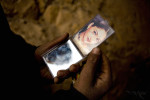 An emerald miner uses a hand held mirror with an image of an model from India after washing himself in the morning in the emerald mines above Khenj, Afghanistan on Wednesday, October 24, 2007. The labor of the mines is conducted by young men who spend a week to seven months on the side of the mountains where no women work.  