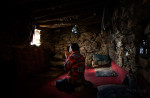 Burhan Amin, 26, prays in the one-room stone house he shares with the rest of his team of miners on the slopes of the Hindu Kush mountains towering over the Panjshir Valley near the village of Khenj, in Afghanistan on Thursday October 25, 2007. Amin, 26, has a kidney ailment that does not allow him to work, brought on from years of battling the mountain for emeralds. Instead of manning the rock drill, Amin prepares the meals of rice, bread, lamb meat and tea for grime-covered miners.  Even with this light duty, he sometimes feels too ill to work. 	“Most of the time I am sick. Those days when I am not feeling well, because there is the mountain and it is the work of the mountain. If we work from the morning till night, you will know how much you get tired,” Amin said. 