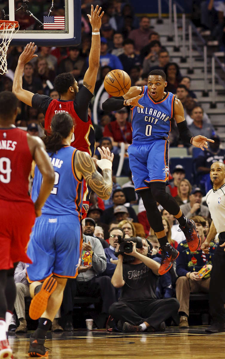 Oklahoma City Thunder guard Russell Westbrook (0) makes a pass to center Steven Adams, second from left, around New Orleans Pelicans forward Anthony Davis, third from left, in the second half of an NBA basketball game in New Orleans, Wednesday, Dec. 21, 2016. (AP Photo/Max Becherer)