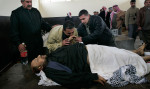 Salim Rahim Judi Yacoubi, gently kisses the hand of the corpse of his brother, Naim, 37, who was killed during a suicide bombing on Election Day in Baghdad. Naim was killed while he was taking tea to election officials at an Iskin neighborhood polling station where he had voted earlier that day. 