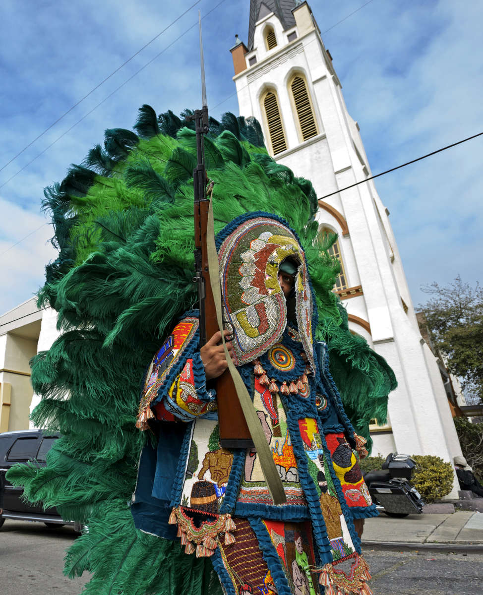Spyboy Samual Fields of the Uptown Warriors holds a SKS, a semi-automatic carbine, with an extended bayonet as he looks for other Indians to challenge with tribal dances and chants in Central City on Mardi Gras day in New Orleans, La., Tuesday, Feb. 13, 2018. Mardi Gras Indian tribes who wear hand-made one of a kind costumes meet other tribes and perform ritual dances and chants all over the city on Mardi Gras Day.