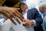 GONZALES, LOUISIANA. Republican presidential candidate Donald Trump, center, and running mate Gov. Mike Pence, right, help to unload supplies for flood victims during a tour of the flood damaged area in Gonzales, La., Friday, Aug. 19, 2016. Trump and Pence traveled to flood-ravaged sections of southern Louisiana to survey the damage that killed at least 13 people and displaced thousands more. (AP Photo/Max Becherer)