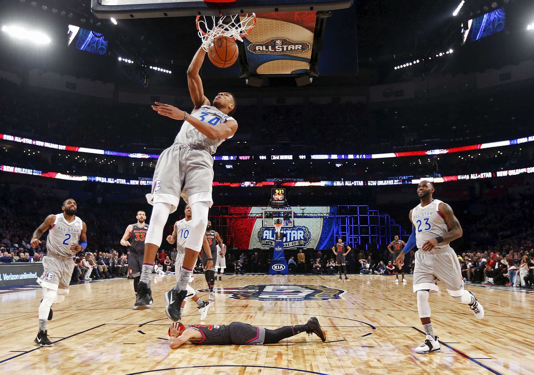 Eastern Conference small forward Giannis Antetokounmpo of the Milwaukee Bucks (34) slam dunks as Western Conference guard Stephen Curry of the Golden State Warriors (30) lies on the court during the first half of the NBA All-Star basketball game in New Orleans, Sunday, Feb. 19, 2017. (AP Photo/Max Becherer)