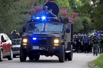 An armored police truck leads a troop of police through a residential neighborhood near a major highway  after clearing protestors from the area in Baton Rouge, La. USA, on Sunday, July 10, 2016. Some 30 to 40 people were taken into custody for trying to block a highway, sheriff's spokeswoman Casey Rayborn Hicks said. Louisiana Gov. John Bel Edwards said he doesn't believe officers have been overly aggressive by using riot gear to push protesters off a highway. {quote}The police tactics in response have been very moderate. I'm very proud of that,{quote} said Edwards (AP Photo/Max Becherer) 