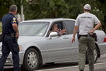 Police stop a car and direct the driver to show his hands after coming from the direction of a police shooting on Airline Highway in Baton Rouge, La. USA, on Sunday, July 17, 2016. The driver's car was searched, his identification checked, then he was allowed to continue. Three officers are confirmed dead and three others wounded after a shooting in Baton Rouge, Casey Rayborn Hicks, a spokeswoman for the East Baton Rouge Sheriff’s Office said. (AP Photo/Max Becherer)