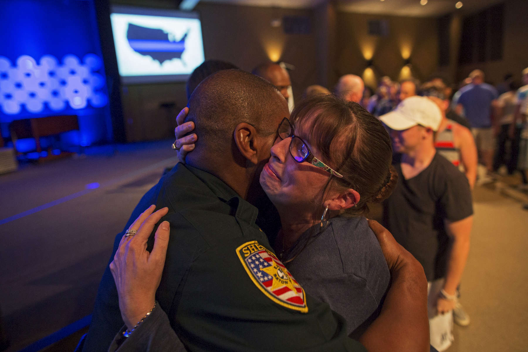 East Baton Rouge Sheriff officer Eddie Guidry, left, is hugged by a teary Terri Carney, both members of The Rock Church on the outskirts of Baton Rouge, during a prayer vigil for the officers killed and wounded by a gunman on Sunday in Zachary, La. USA, Monday, July 18, 2016. About 100 people came to the special hour-long prayer vigil. Col. Michael Edmonson, superintendent of the Louisiana State Police, said at a news conference that day: “There is no doubt whatsoever that these officers were intentionally targeted and assassinated.{quote} (AP Photo/Max Becherer)